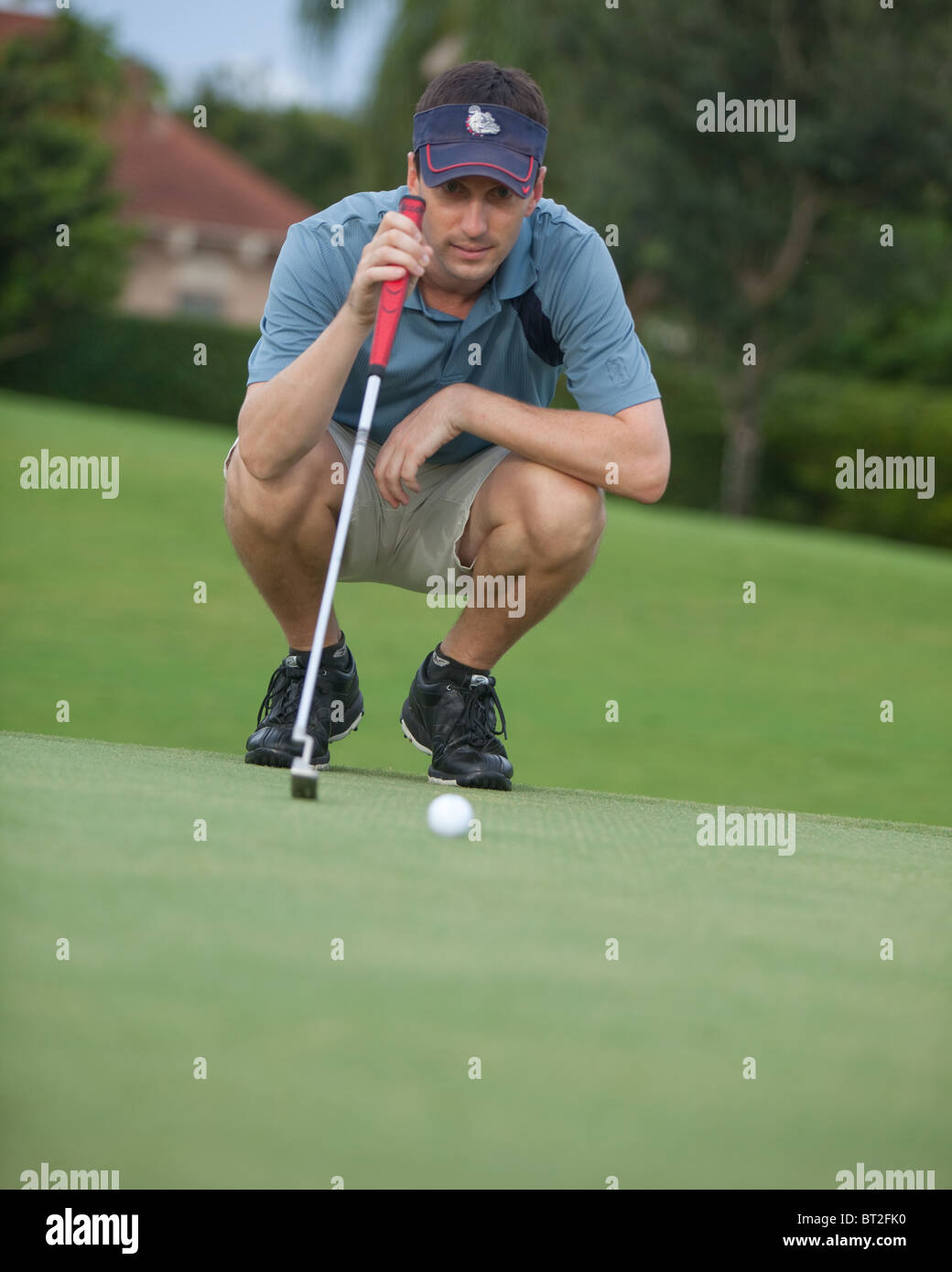 Il Golfer studia il suo messo sul verde Foto Stock