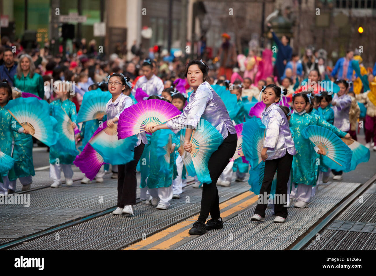 Donna cinese leader di un gruppo di bambini in le prestazioni della ventola durante il Nuovo Anno Cinese parade di San Francisco, California, Stati Uniti d'America. Foto Stock