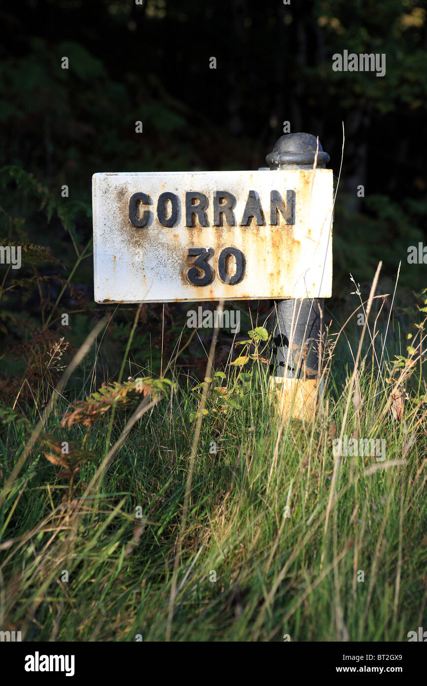 Mile marker che mostra Corran è 30 miglia di distanza Foto Stock