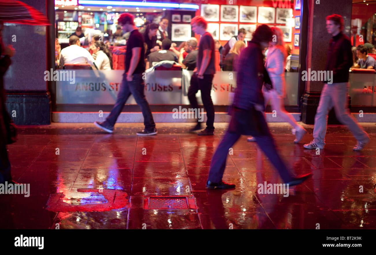 La gente camminare sotto la pioggia nel West End di Londra Foto Stock