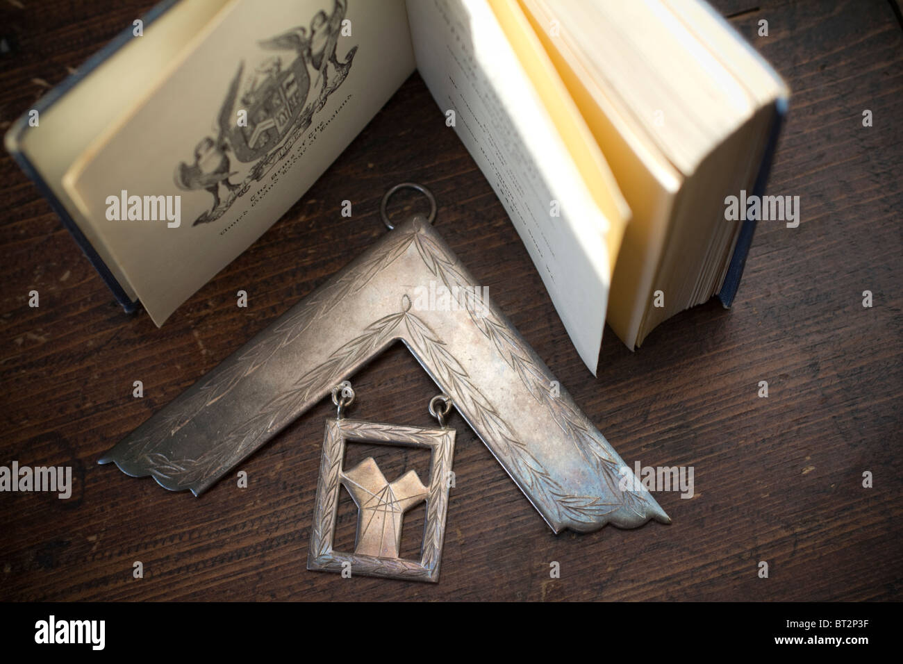 Massone massone, Medaglia del passato massonico, simbolo quadrato ad angolo retto. Con Freemason book Londra Regno Unito Foto Stock