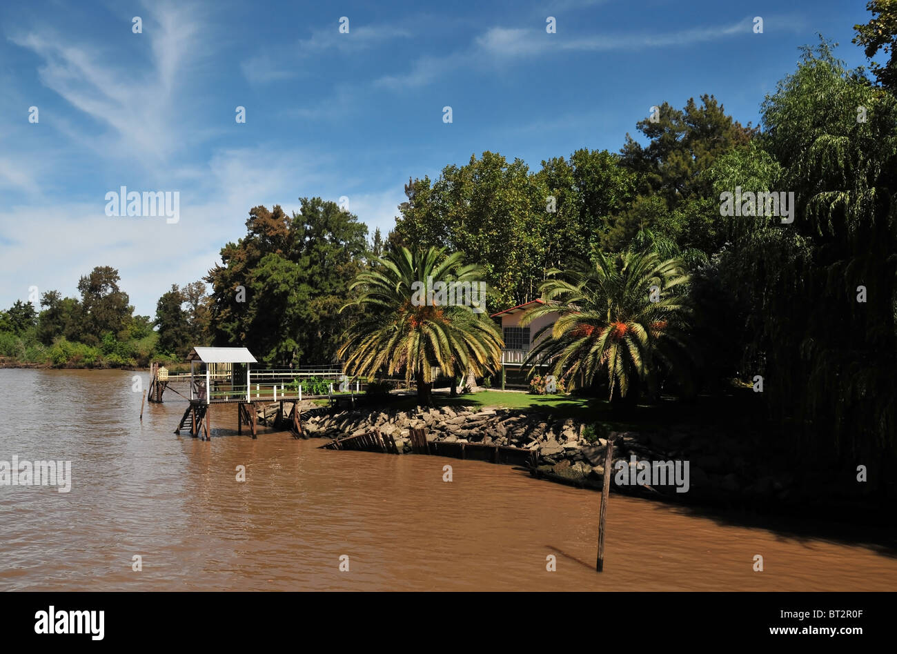 Vista obliqua boscoso di banca di fiume, molo, palme e holiday bungalow, Sarmiento Fiume Parana Delta, Buenos Aires Foto Stock