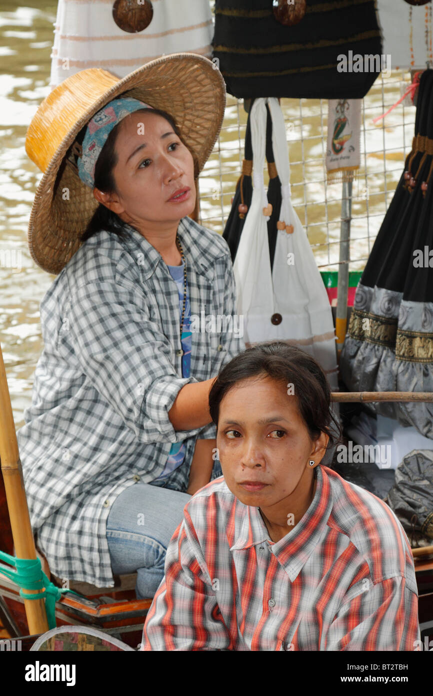 Anziana donna Thai venditore a vendere prodotti alimentari a sua barca a remi (barca a remi), al Mercato Galleggiante di Bangkok, Tailandia, Settembre 2010 Foto Stock