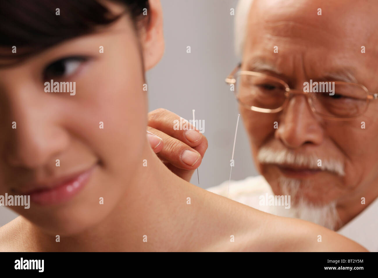 Medico di mettere gli aghi di agopuntura sulla donna il collo , close-up Foto Stock