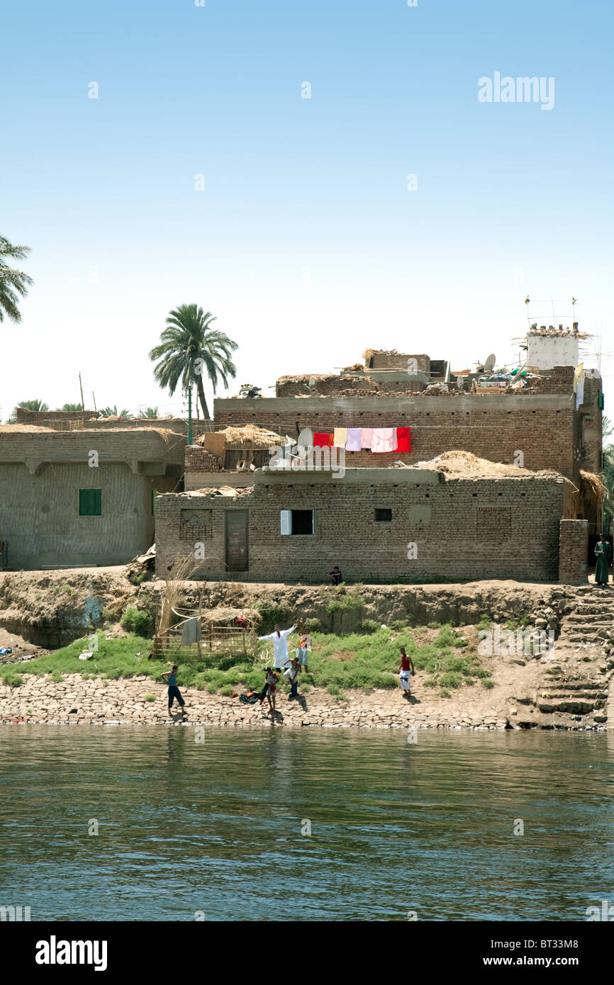 Locale egiziano di bambini che giocano sulle rive del fiume Nilo vicino a Aswan, Alto Egitto Foto Stock