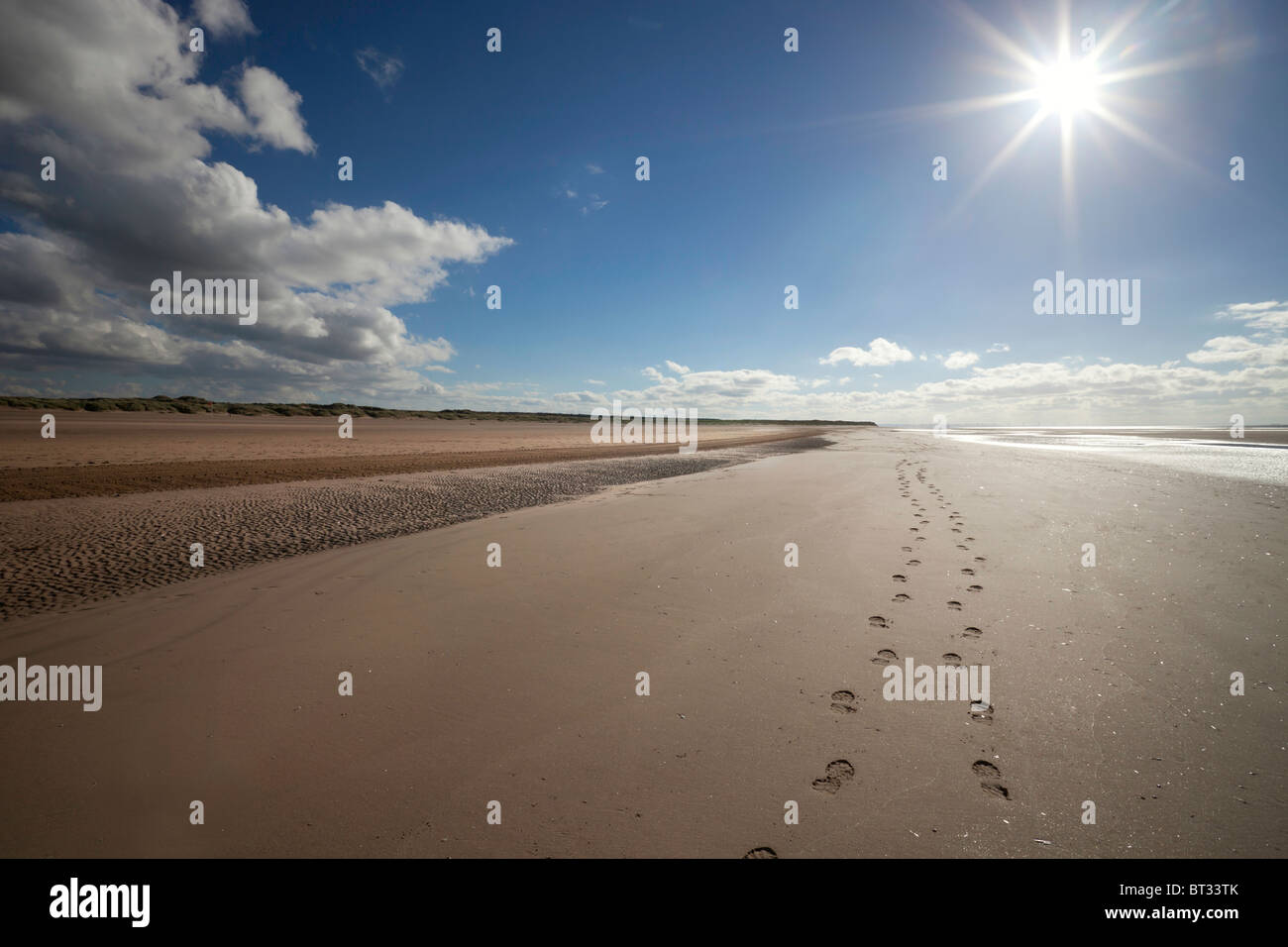 Una scia di orme nella sabbia lungo la spiaggia Ainsdale, Southport. È situato sulla costa di Sefton, Regno Unito ed è molto popolare spiaggia di ricreazione. Foto Stock