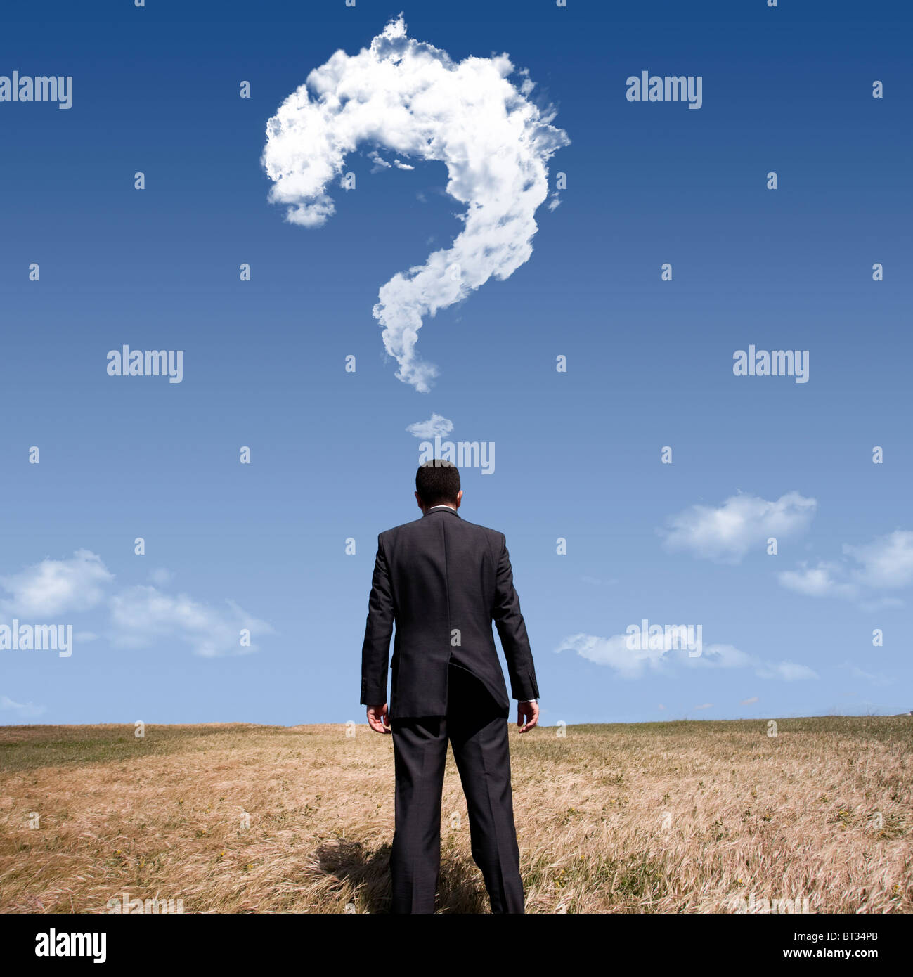 Imprenditore in piedi da solo al campo con un sacco di domande nella sua mente Foto Stock