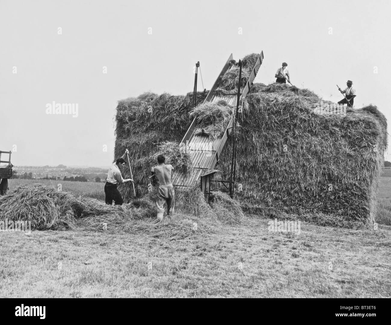 Vintage immagini agricole dal 1930 un legante il lavoro dei campi e in seguito la realizzazione di un pagliaio Foto Stock