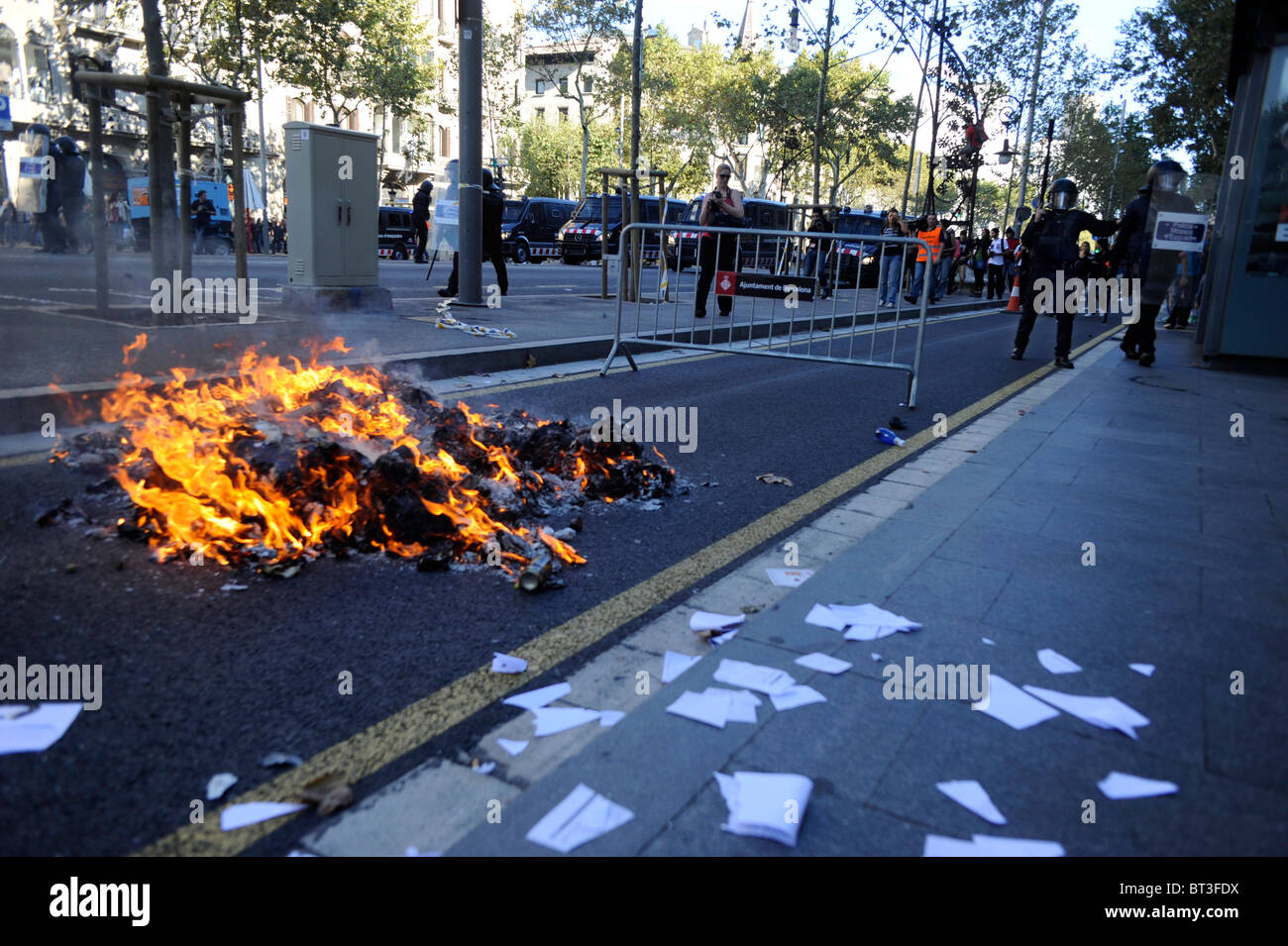Sacchi della spazzatura dato alle fiamme in scontri al centro della città di Barcellona durante lo sciopero generale in Spagna. Foto Stock