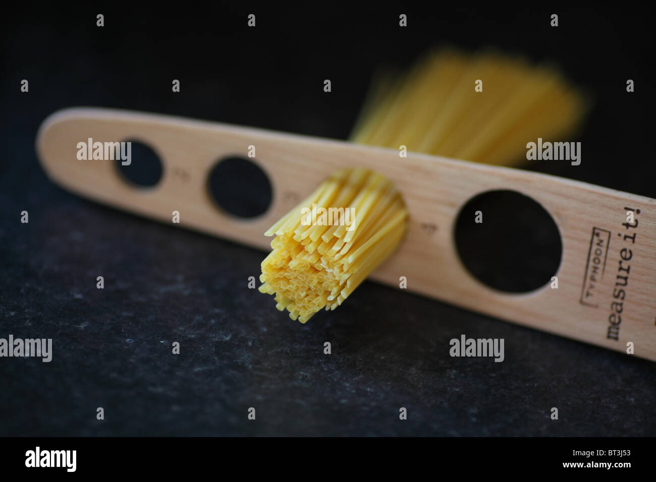 Linguine essiccato in una misura di legno. Foto Stock