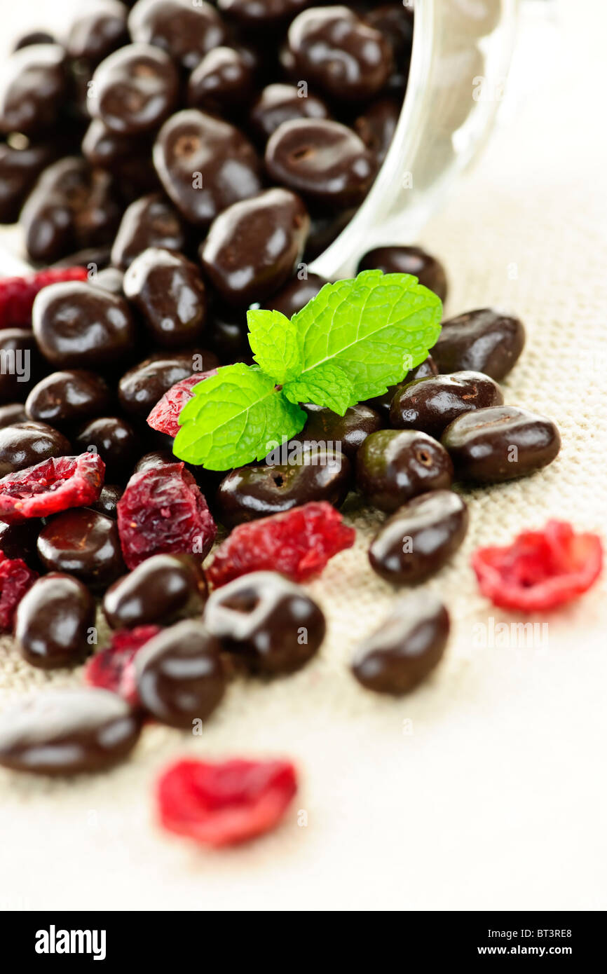 Ricoperta di cioccolato mirtilli fuoriuscita dal piatto di vetro Foto Stock