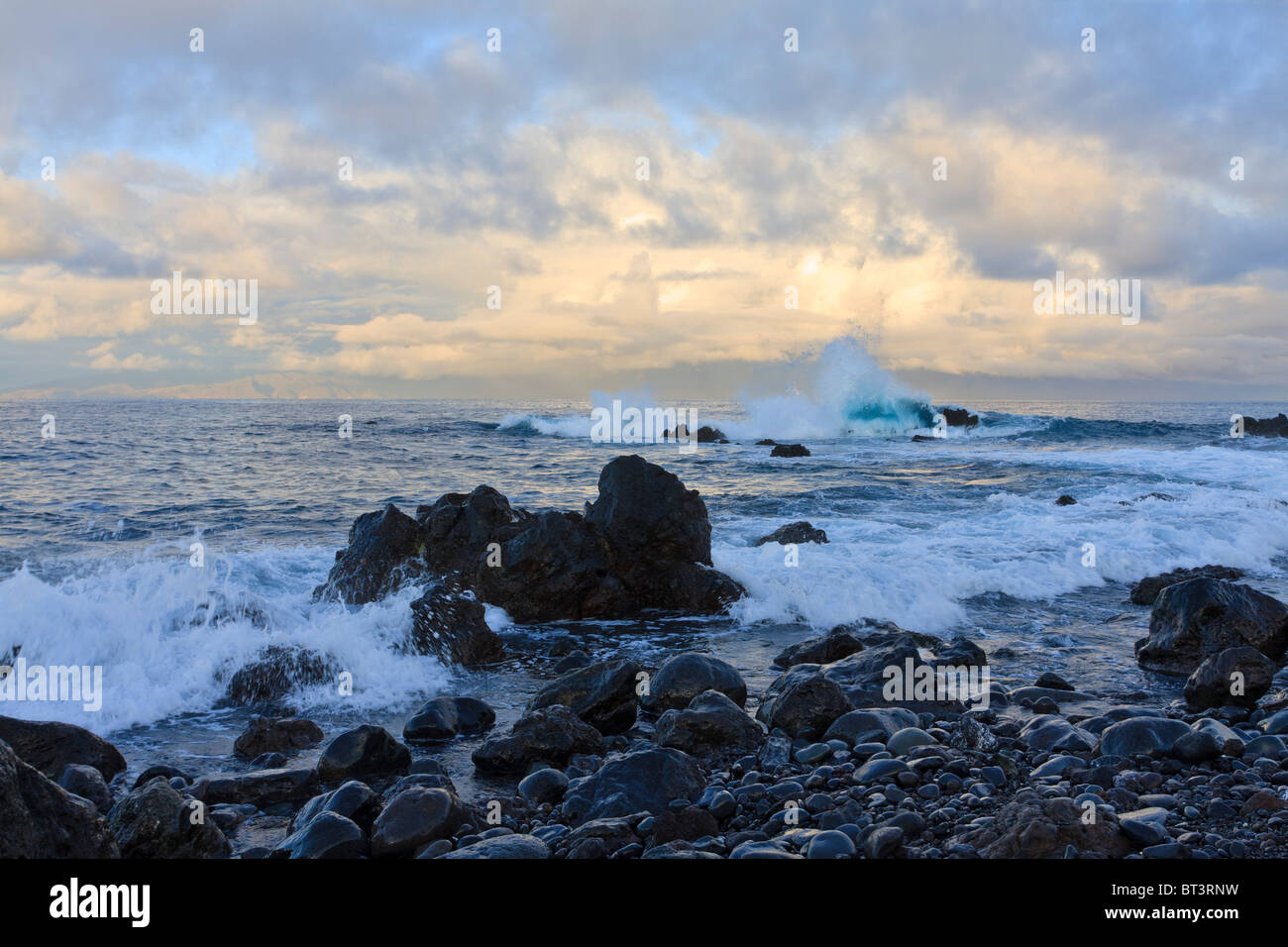 Le onde rompono sulle rocce all'alba sulla costa vicino a Playa San Juan Tenerife Canarie Spagna Europa Foto Stock