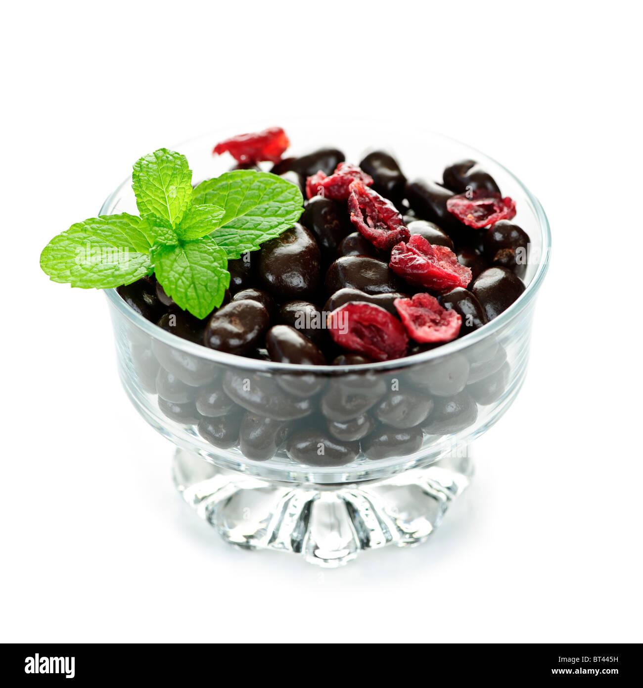 Il cioccolato di mirtilli rossi rivestito in recipiente di vetro su sfondo bianco Foto Stock