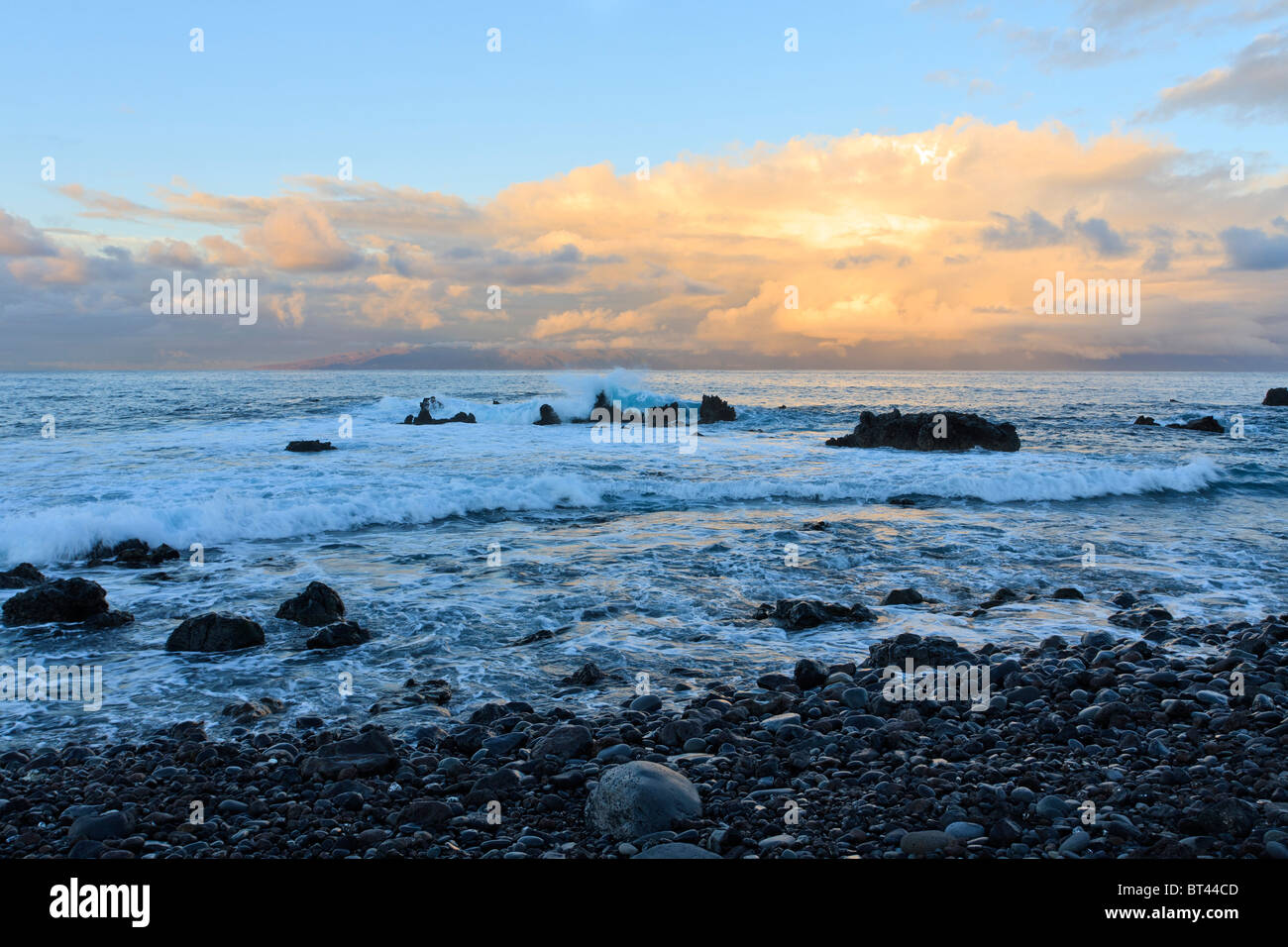 Le onde rompono sulle rocce all'alba sulla costa vicino a Playa San Juan Tenerife Canarie Spagna Europa Foto Stock