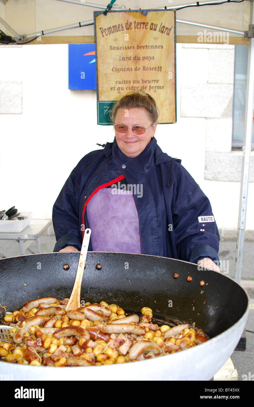 Donna vendita bretone tradizionale salsiccia di maiale e patate al mercato francese in Bretagna, Francia Foto Stock