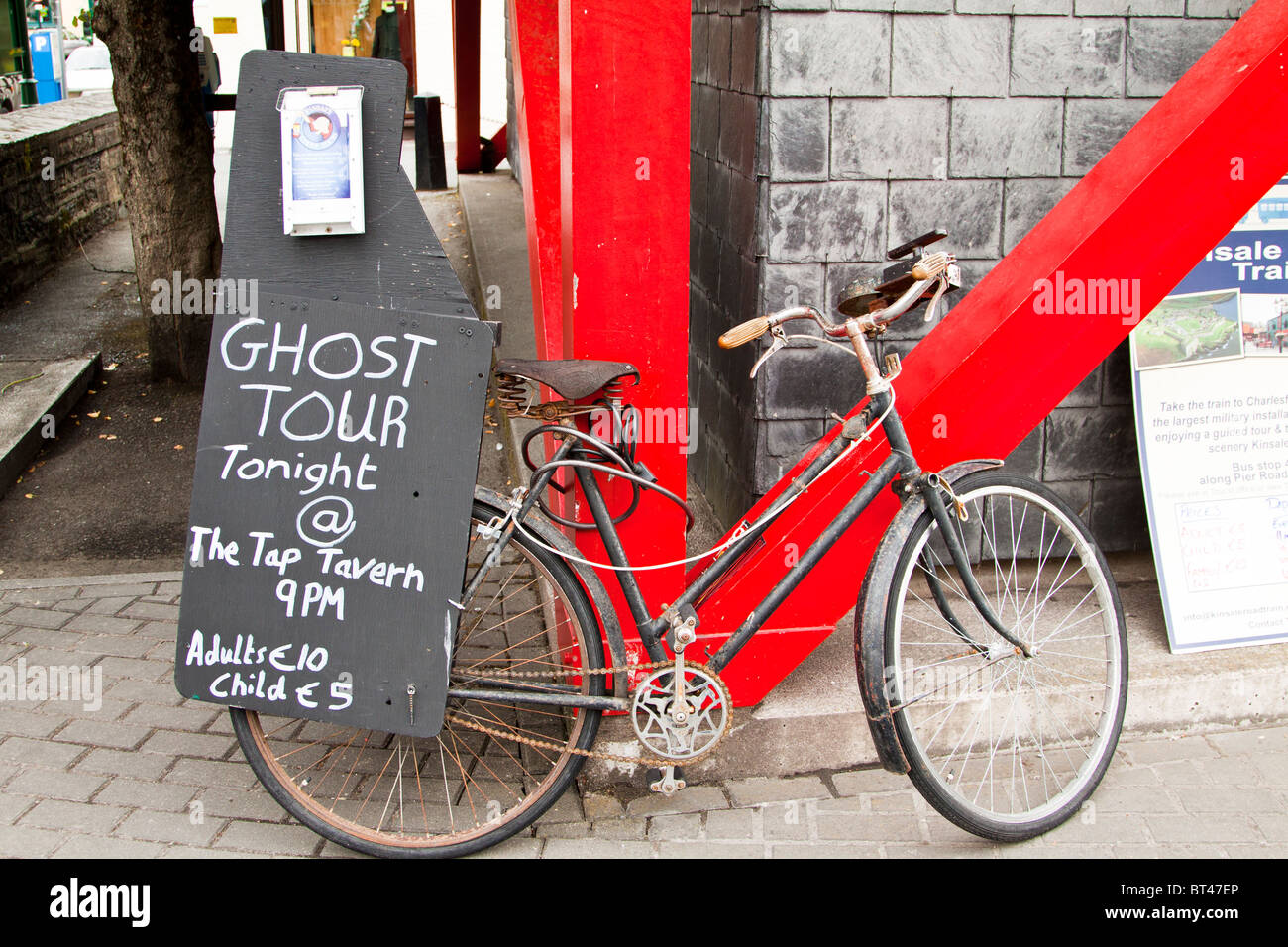 Vecchia bicicletta con segno pubblicità tour fantasma. Kinsale, Cork, Irlanda Foto Stock