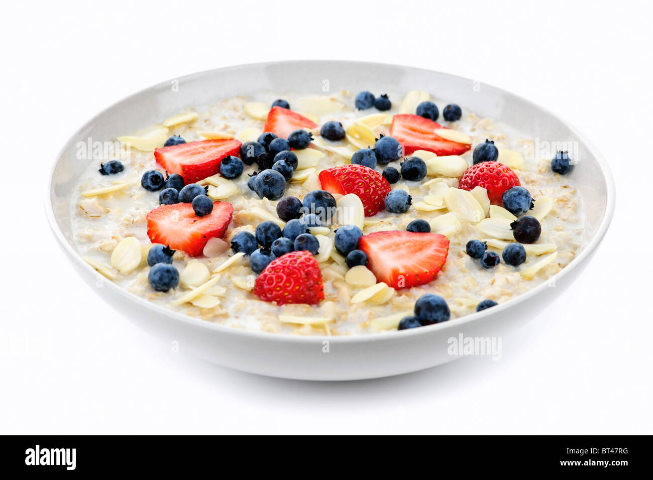 Ciotola di fiocchi d'avena caldi la colazione a base di cereali con frutti di bosco freschi Foto Stock