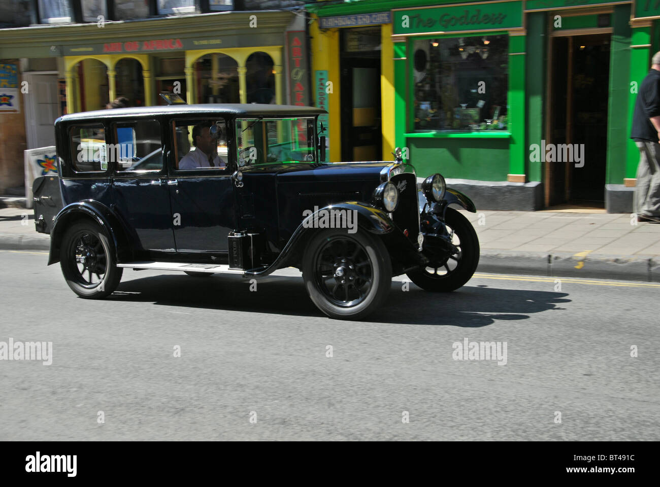 Vintage Austin sei guidando attraverso Glastonbury High Street Somerset REGNO UNITO Foto Stock