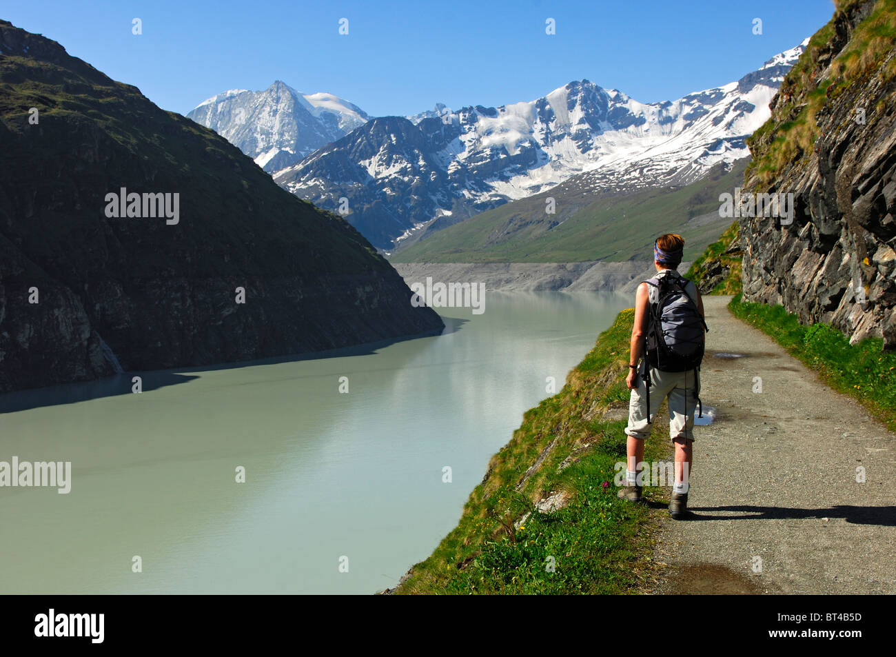 Escursionista presso il lago di storage Lac des Dix con Mt. Mont Blanc de Cheilon nel retro, Val d'Herens valley, Vallese, Svizzera Foto Stock
