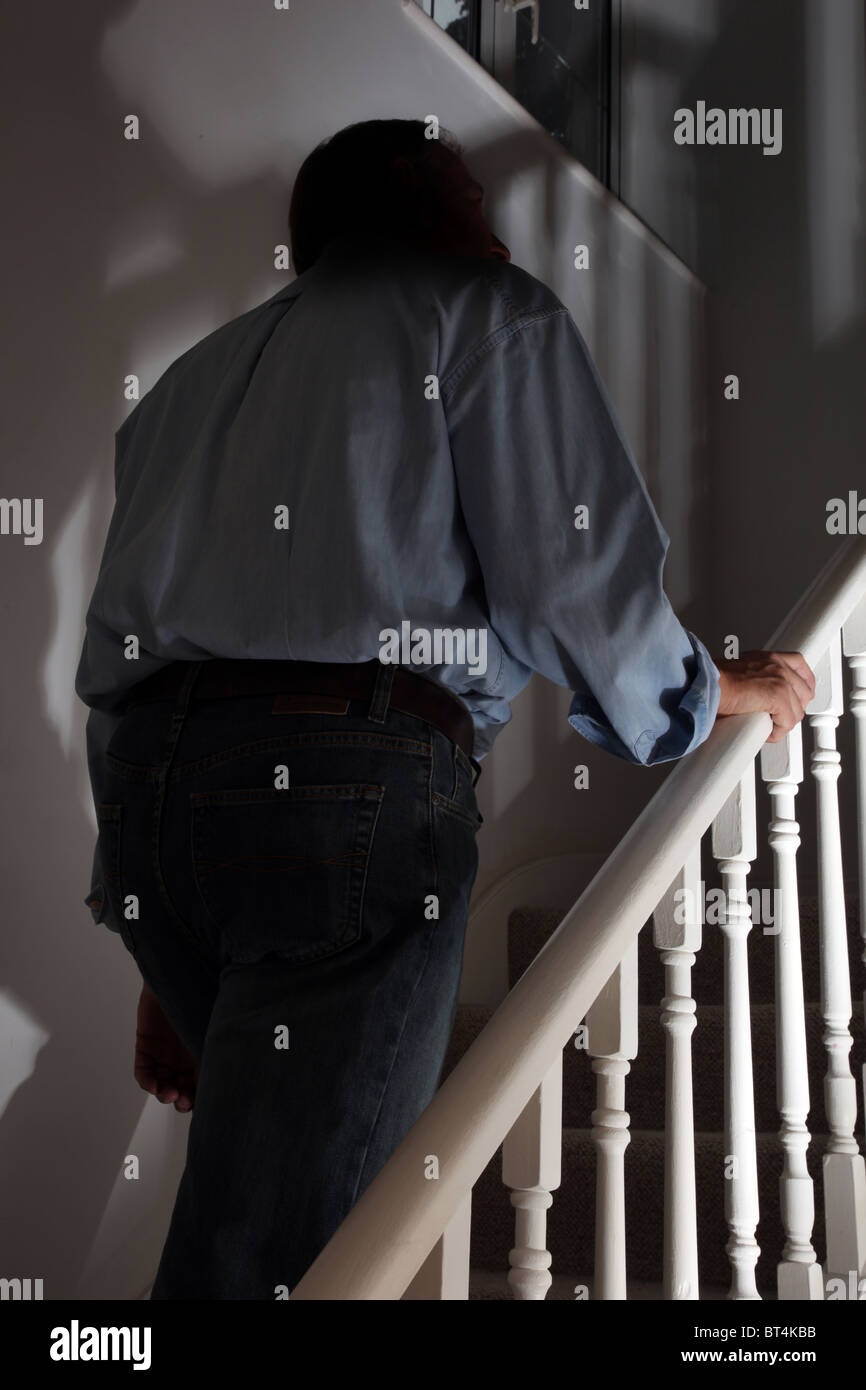 Figura scura di un uomo a camminare al piano superiore vista posteriore Foto Stock