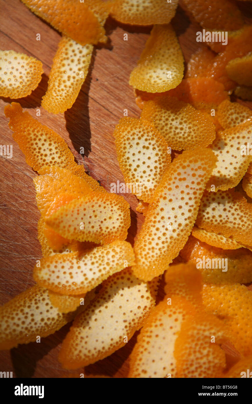 Strati di buccia d'arancia su un tagliere di legno. Foto Stock