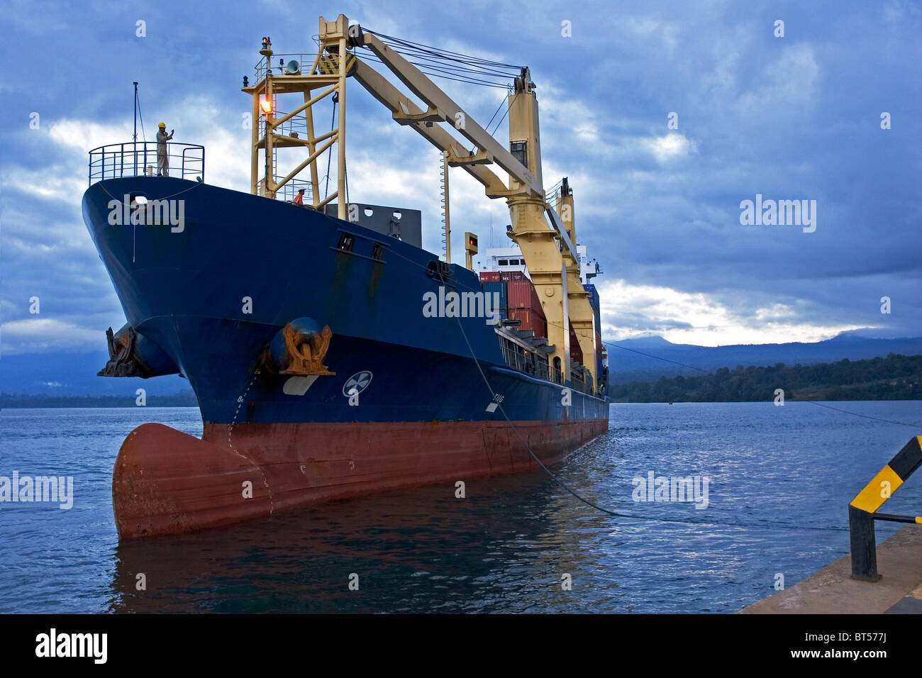 Olio di Luba Freeport. Nave container che arrivano al porto molo al tramonto prima del caricamento di carico dei contenitori Foto Stock