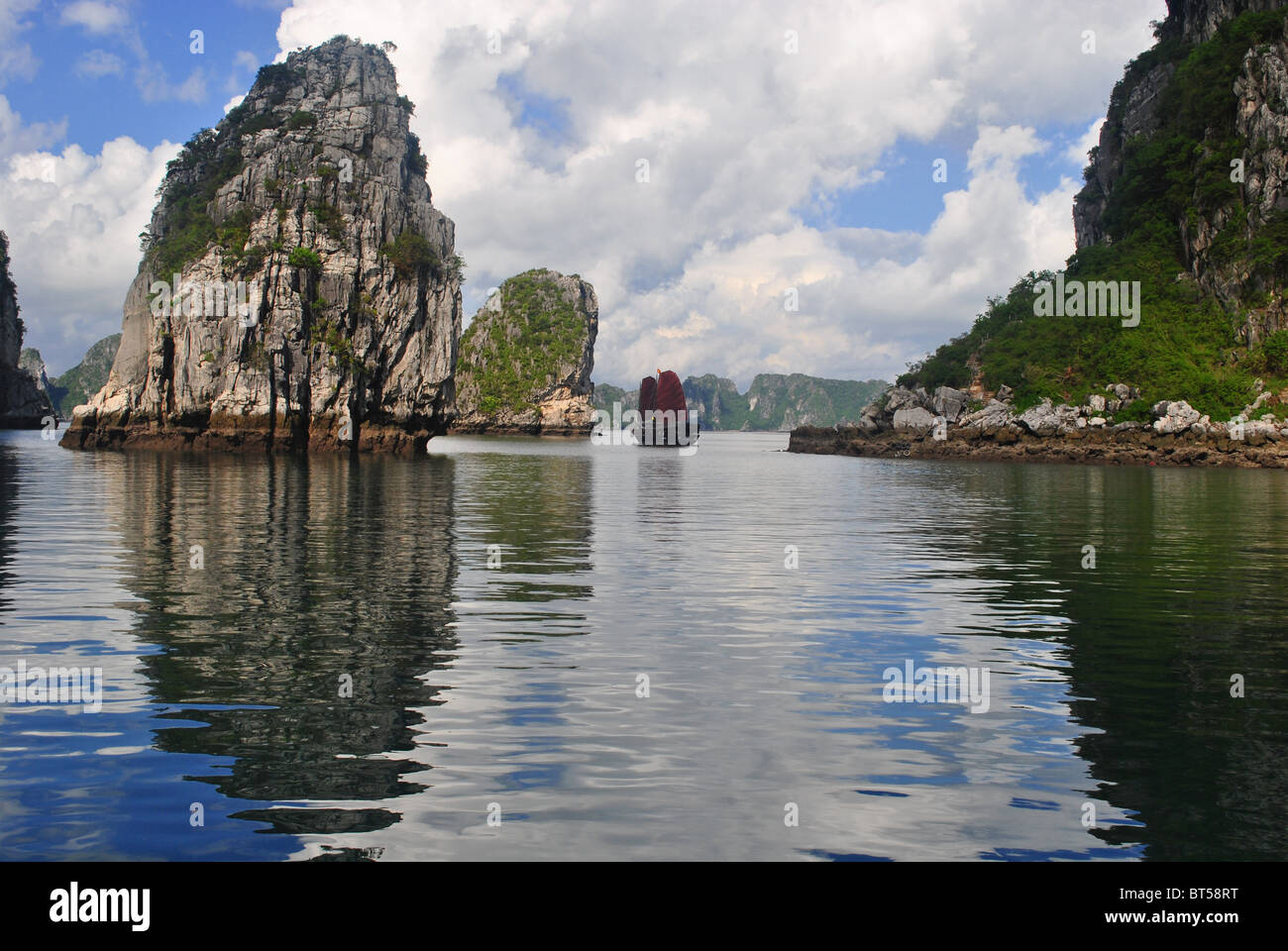 Junk con il red sail tra isole calcaree nella baia di Ha Long, Vietnam Foto Stock