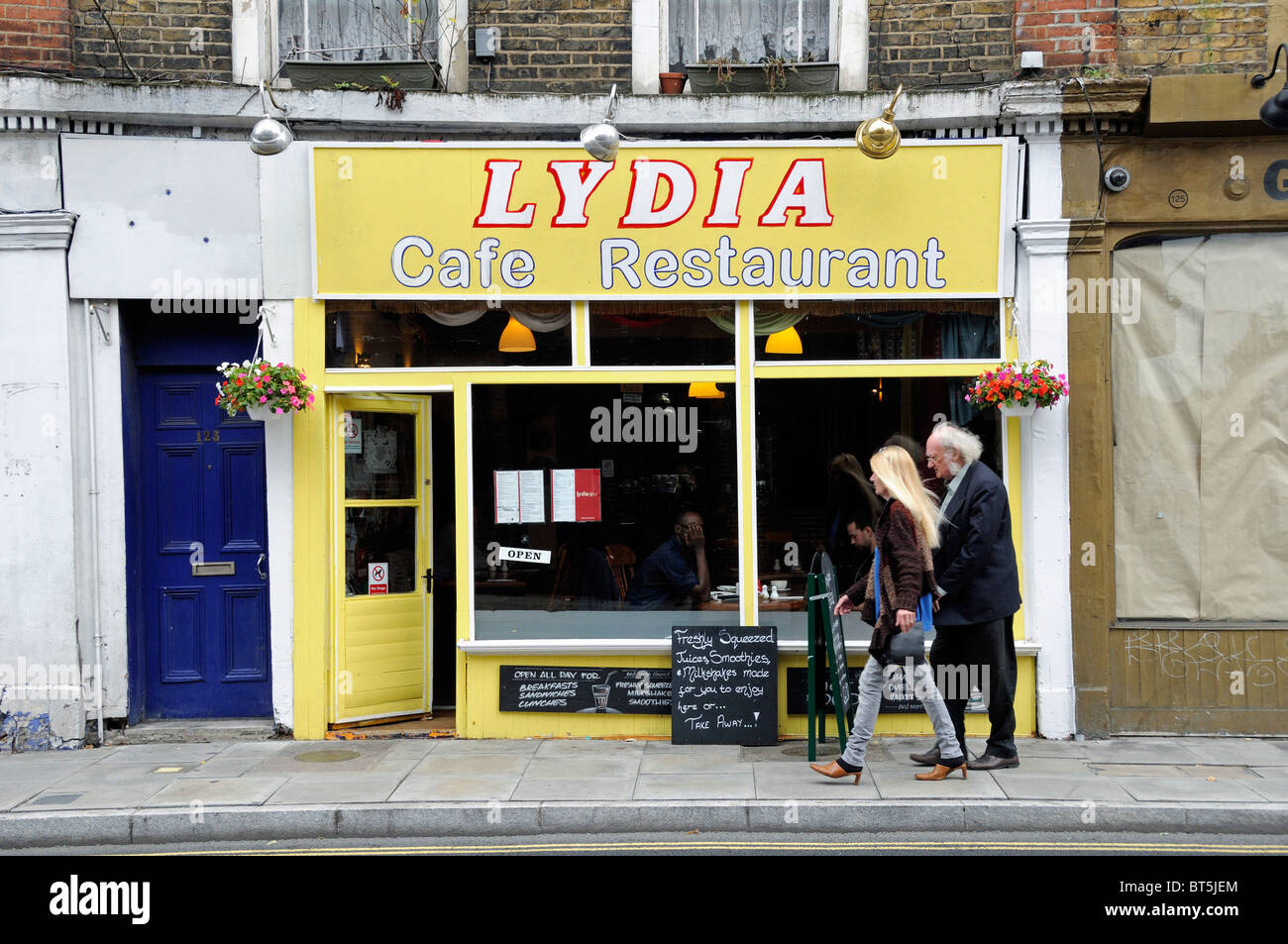 Lydia cafe ristorante con persone di passaggio, Stoke Newington Church Street a Londra England Regno Unito Foto Stock