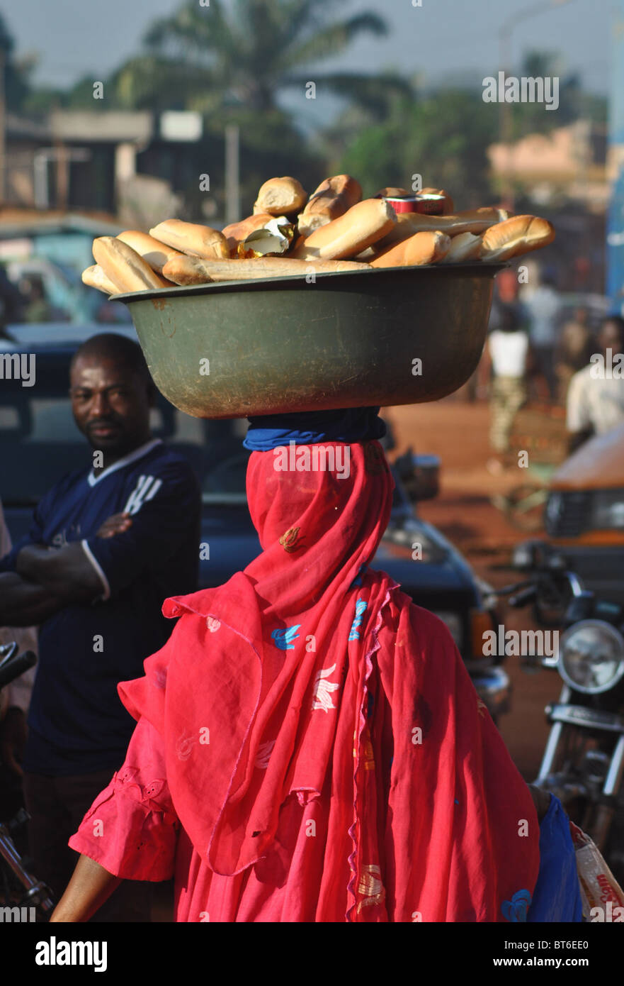 Donna baguette di vendita sulla strada nell'uomo, Costa d Avorio, Africa occidentale Foto Stock