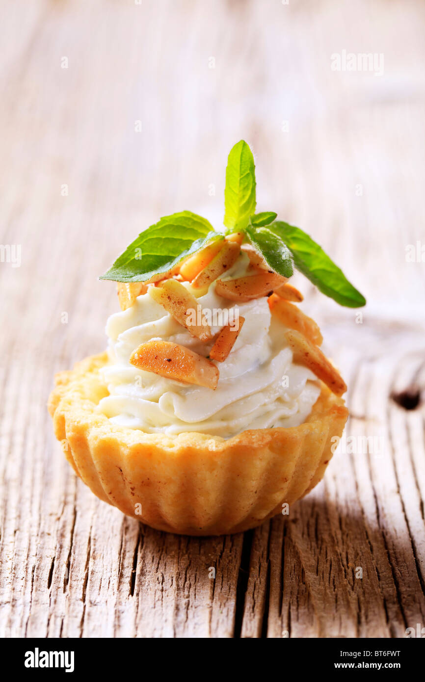 Tart shell con la gustosa diffondere il riempimento e rabboccato con mandorle tostate Foto Stock