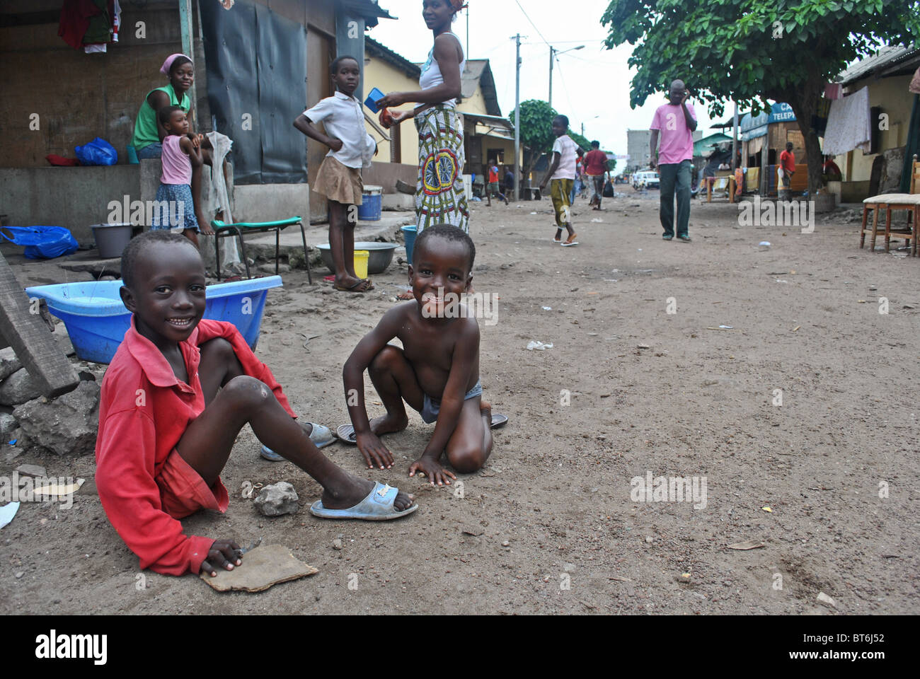 Bambini giocano su una strada fangosa in Treicheville, Abidjan, Costa d'Avorio, Africa occidentale Foto Stock