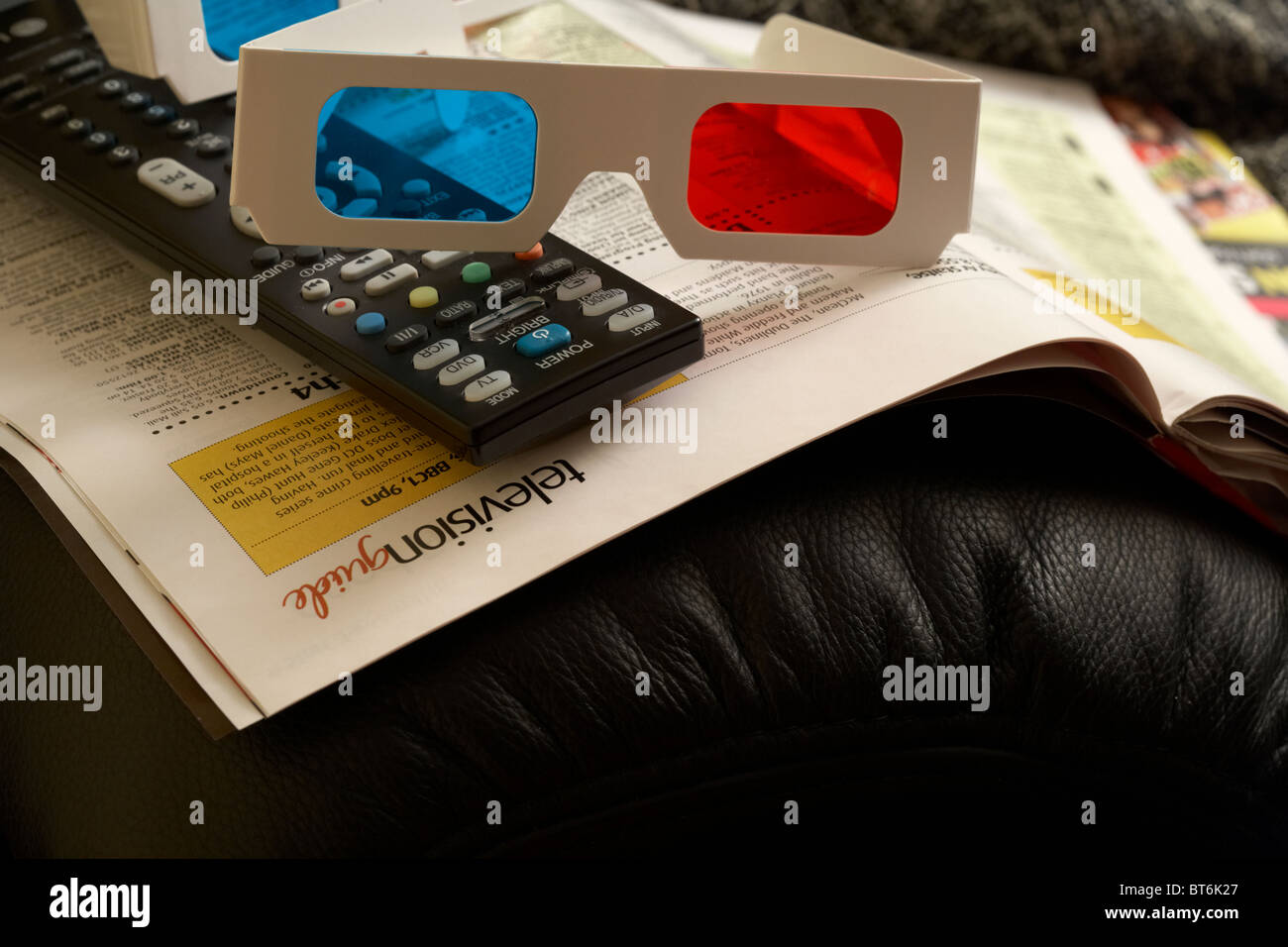 Occhiali 3d e telecomando TV seduti sulla parte superiore dei televisori  riviste sul braccio di una sedia Foto stock - Alamy