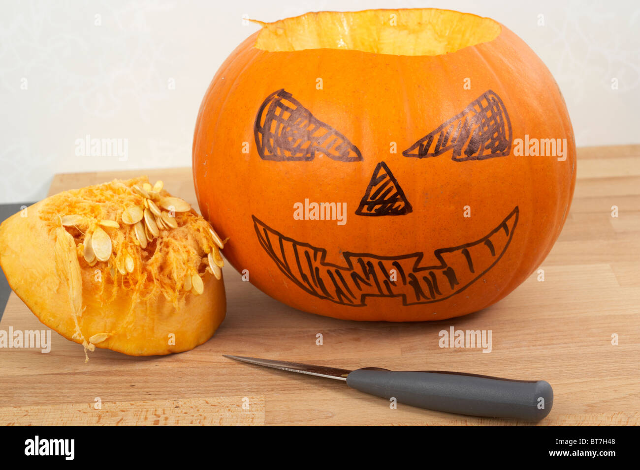 La zucca parzialmente trasformato in halloween jack-o-lantern con top cut fuori e caratteristiche del viso segnata a penna con coltello Foto Stock La zucca parzialmente trasformato in halloween jack-o-lantern con top cut fuori e caratteristiche del viso segnata a penna con coltello Foto Stock