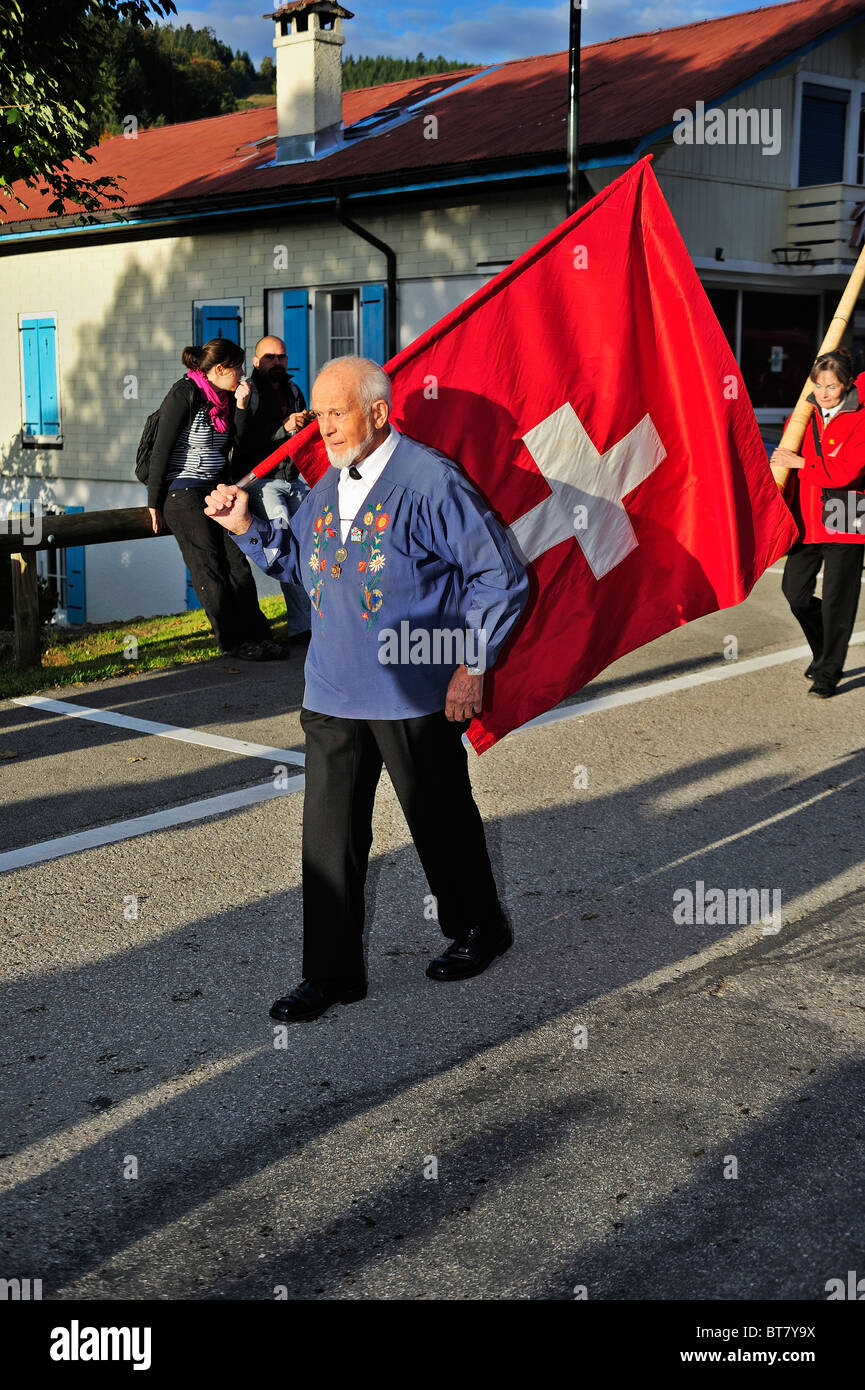 Bandiera svizzera l'uomo. Una vecchia bandiera svizzera-thrower marciare alla testa di una processione. Foto Stock