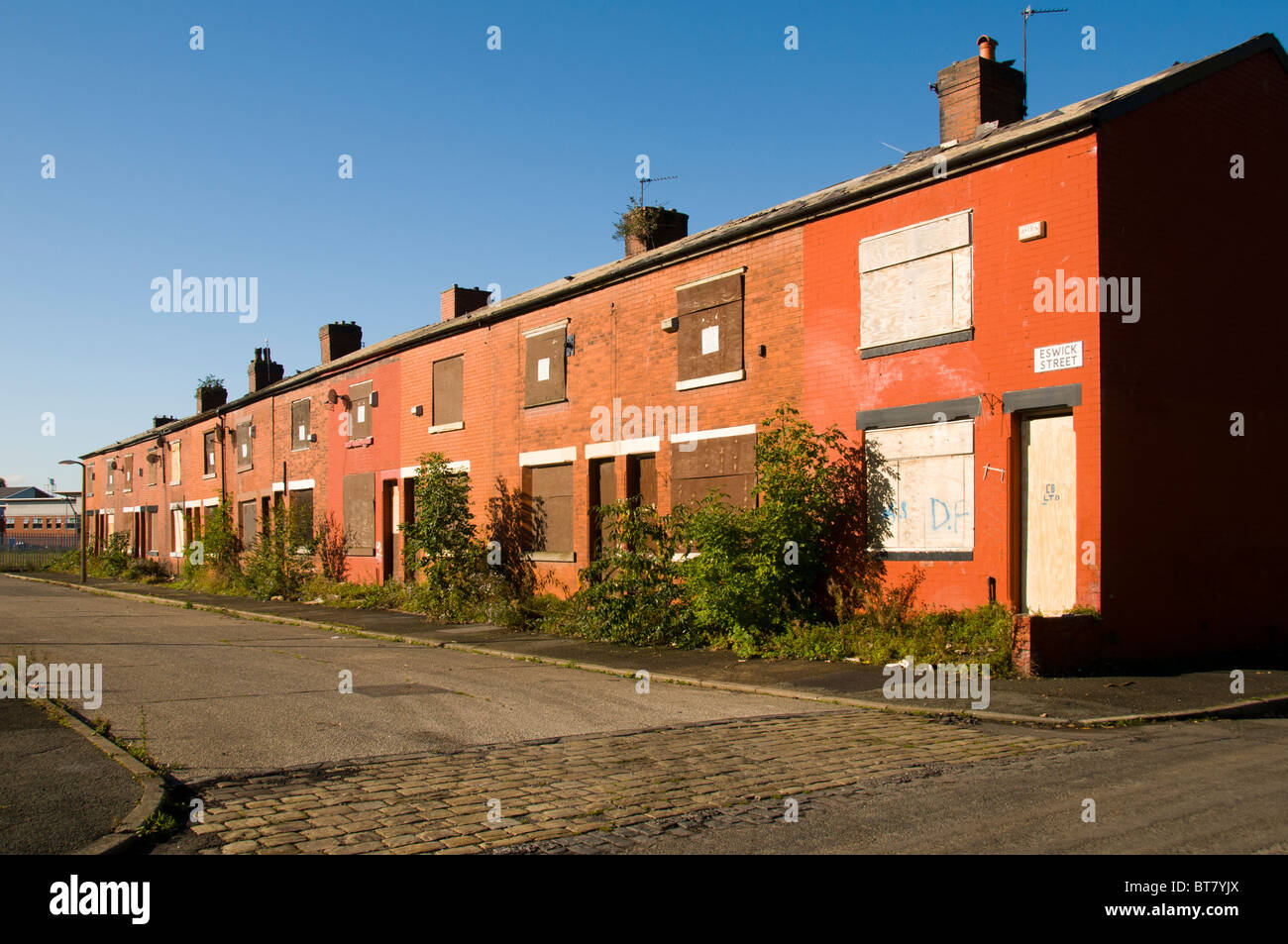 Una fila di terrazzamenti abbandonati alloggiamento in attesa di demolizione in Clayton distretto di Manchester, Inghilterra, Regno Unito Foto Stock