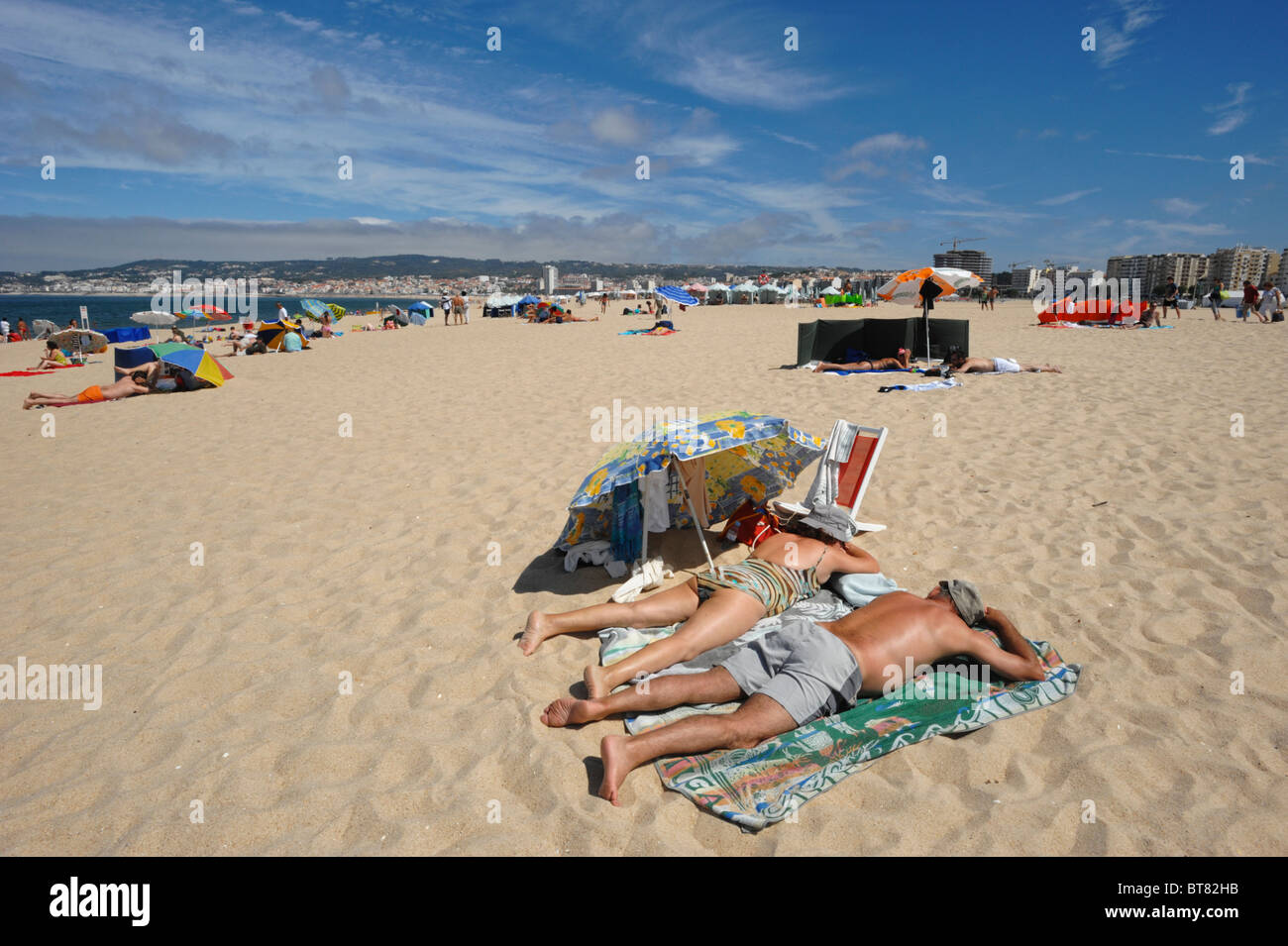 Due dei cittadini anziani a prendere il sole sulla sabbia a Figueira da Foz Beach, Portogallo Foto Stock