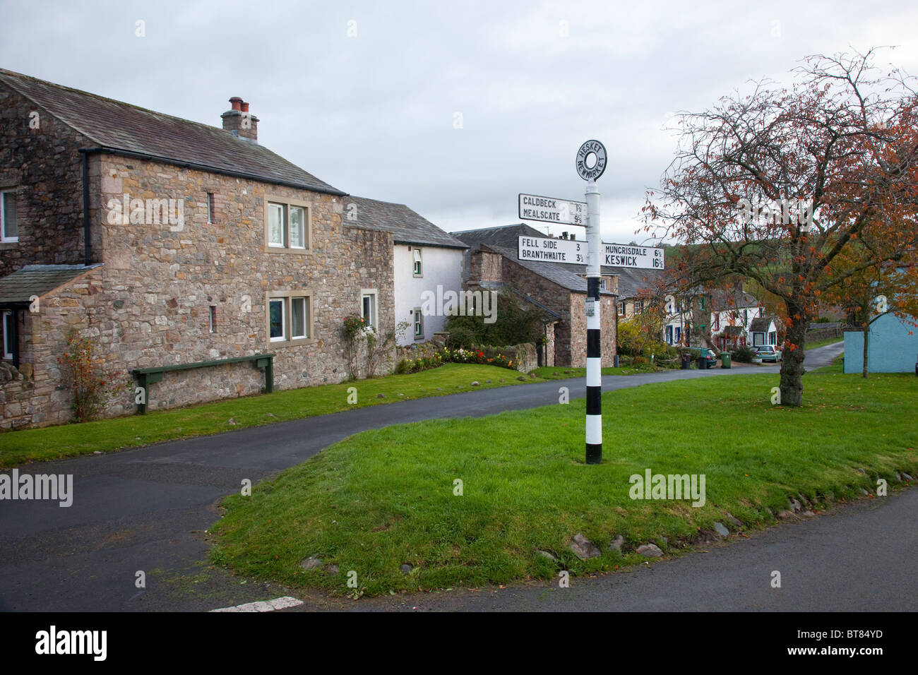 Case e cartello stradale nel villaggio di Hesket Newmarket Cumbria, England, Regno Unito Foto Stock