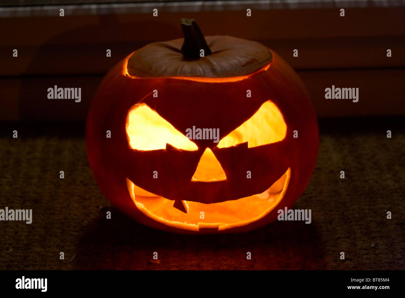 Illuminata la zucca di halloween jack-o-lantern al di fuori di una casa per allontanare gli spiriti maligni Foto Stock