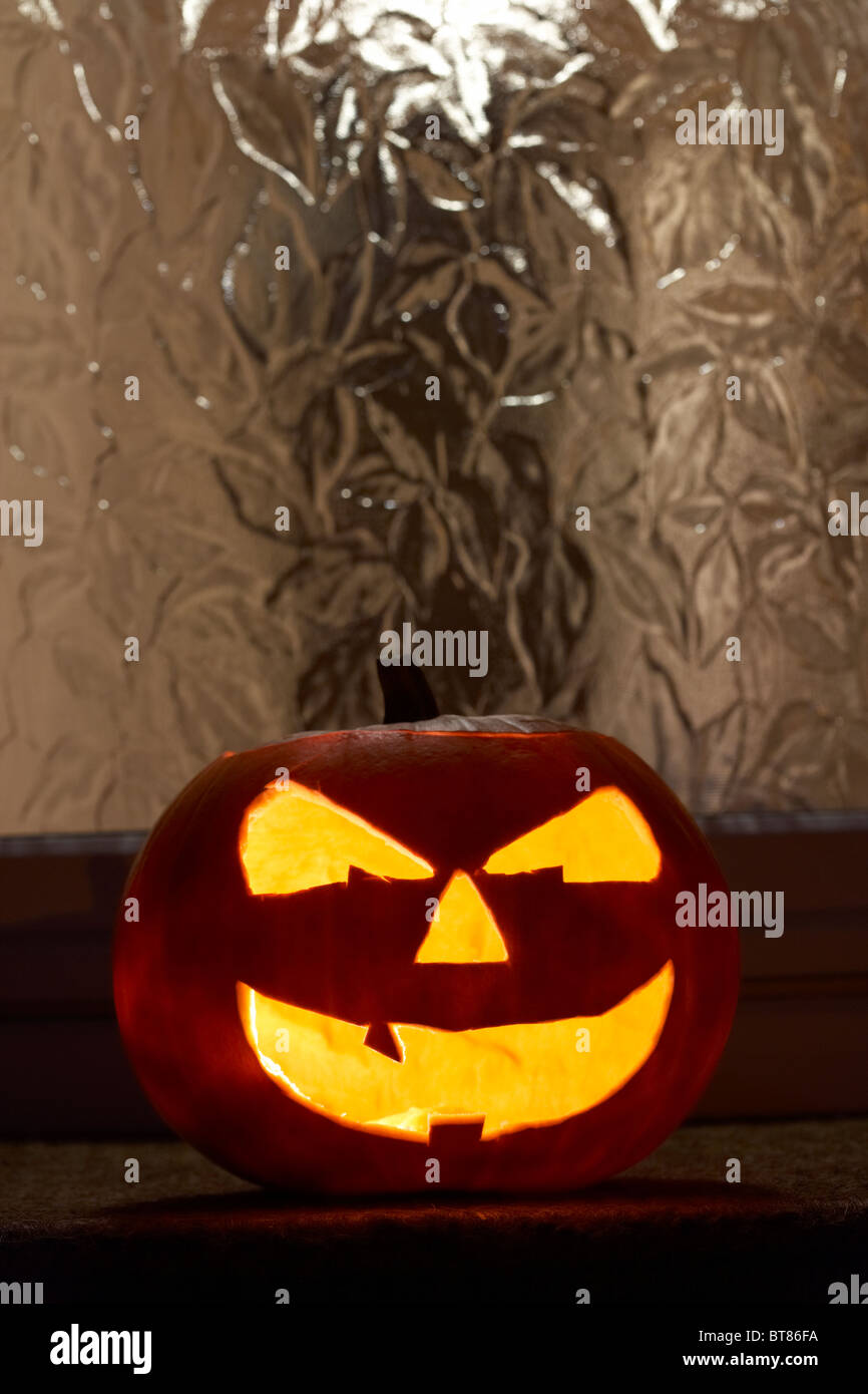 Illuminata la zucca di halloween jack-o-lantern al di fuori di una casa per allontanare gli spiriti maligni Foto Stock