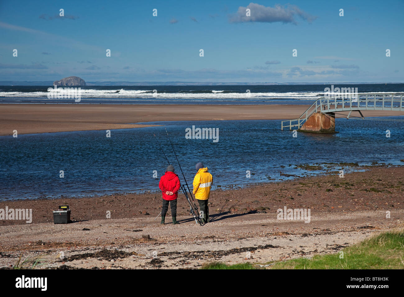 Gli uomini della pesca in mare Belhaven Bay Beach, East Lothian in Scozia, Regno Unito, Europa Foto Stock