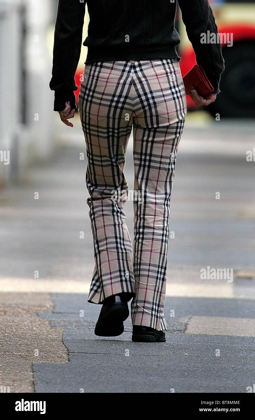 Una donna che indossa Burberry controllare i pantaloni passeggiate lungo la  strada. Foto di James Boardman Foto stock - Alamy