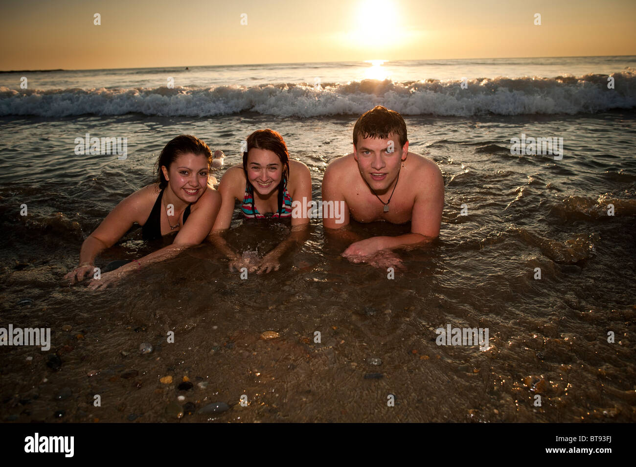 Gli studenti universitari in mare godendo il insolitamente caldo sole di ottobre , Aberystwyth Wales UK. Foto Stock