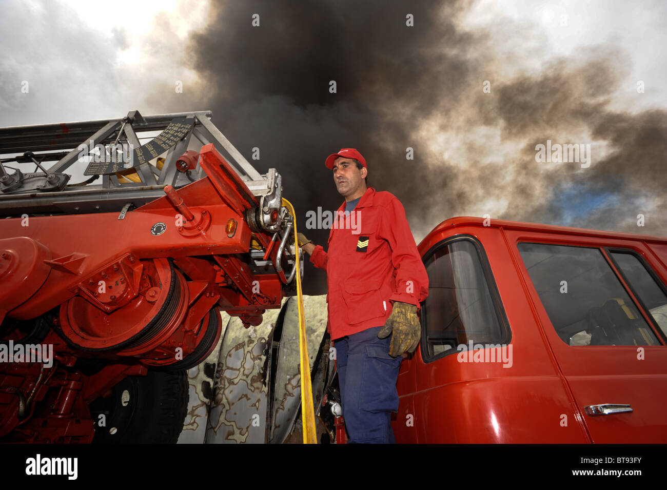 Fireman accanto a un camion dei pompieri Foto Stock