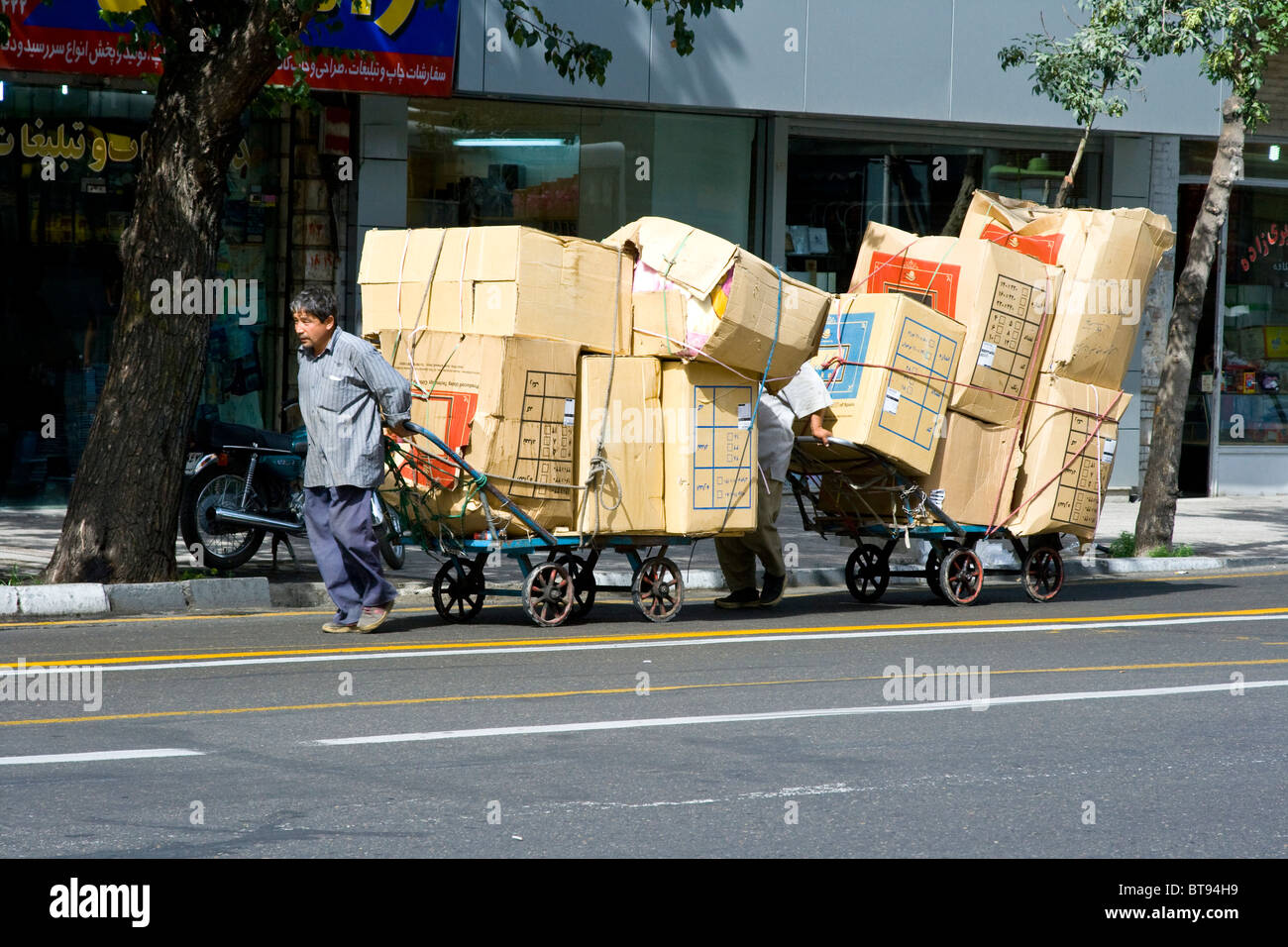 Gli uomini trasporta merci al Bazaar di Teheran, Iran Foto Stock