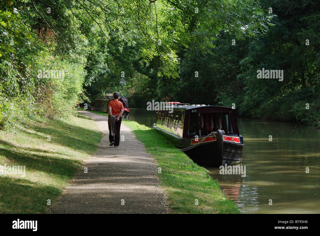 Una donna con la possibilità di passeggiare lungo il Grand Union Canal at Stoke Bruerne, Northamptonshire, Regno Unito Foto Stock