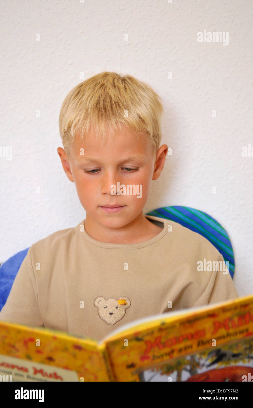 Piccolo Ragazzo guardando un libro Foto Stock