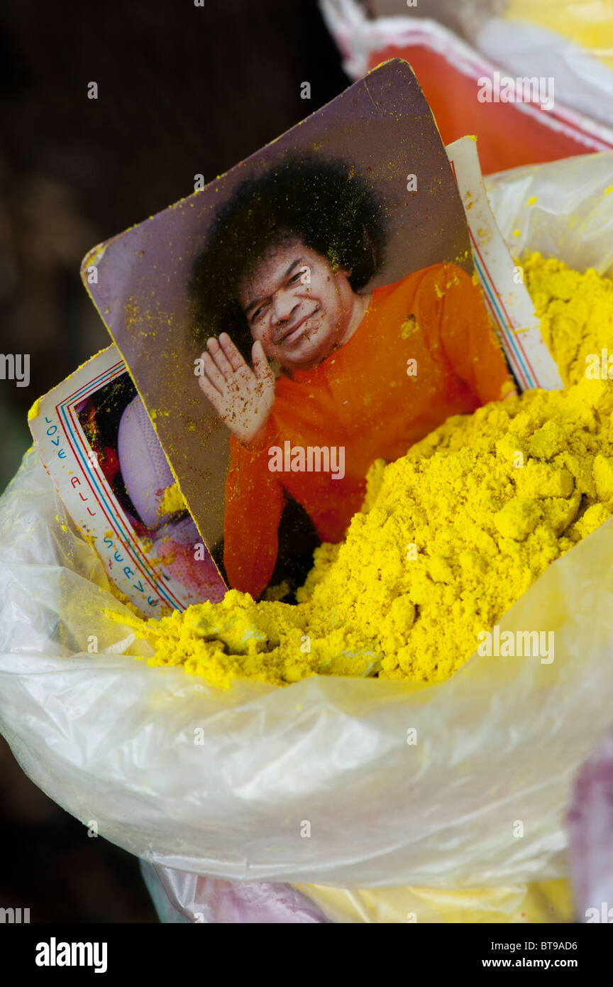 Bhagavan Sri Sathya Sai Baba foto colorata in giallo in polvere in un mercato indiano. Puttaparthi, Andhra Pradesh, India Foto Stock