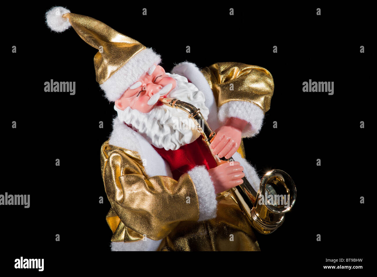 Santa Claus figura vestita in oro sassofono isolato su nero Foto Stock