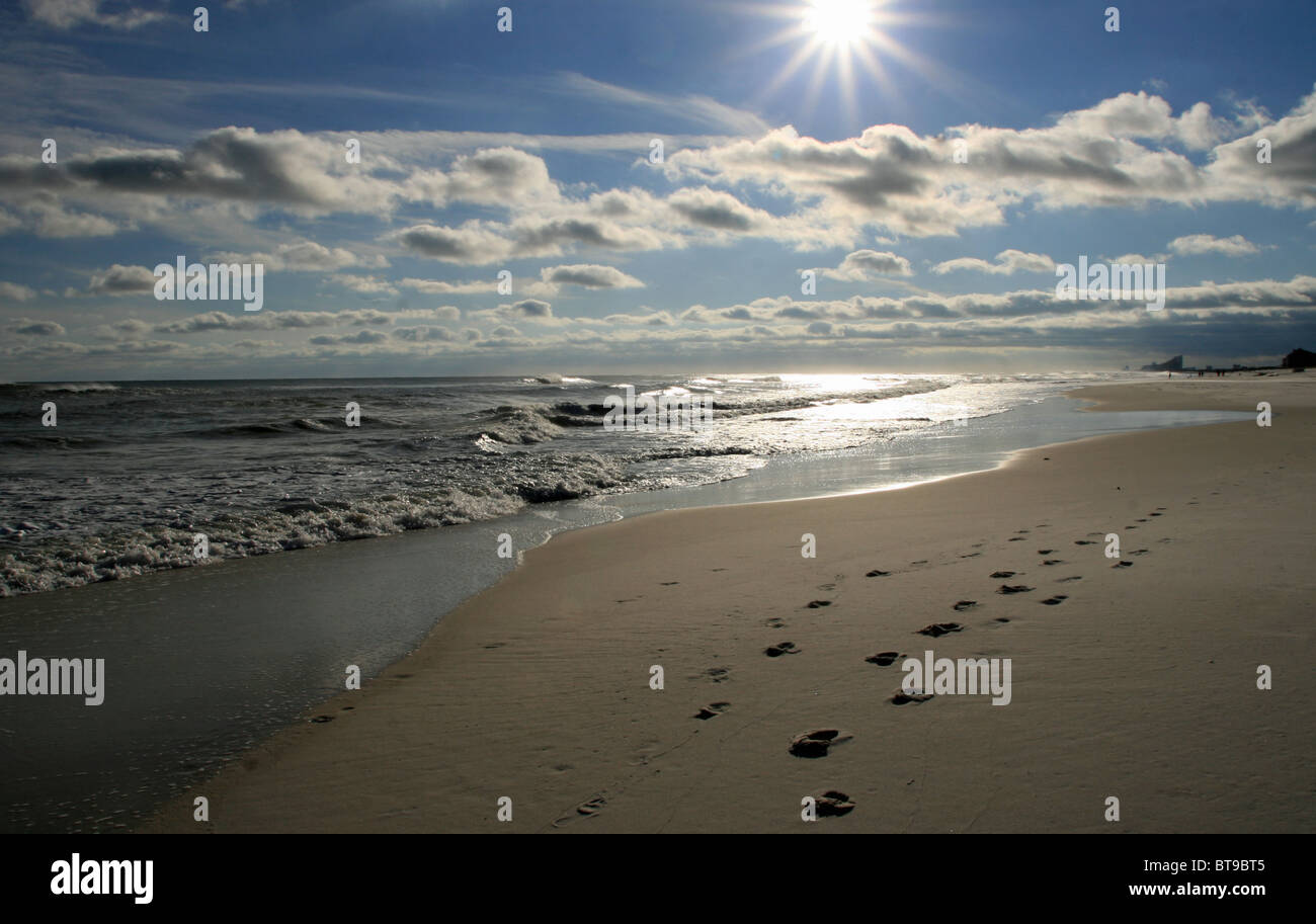 Litorale scintillante con sabbia sun nuvole e acqua con foodprints nella sabbia in Florida e Alabama linea di galleggiamento Foto Stock
