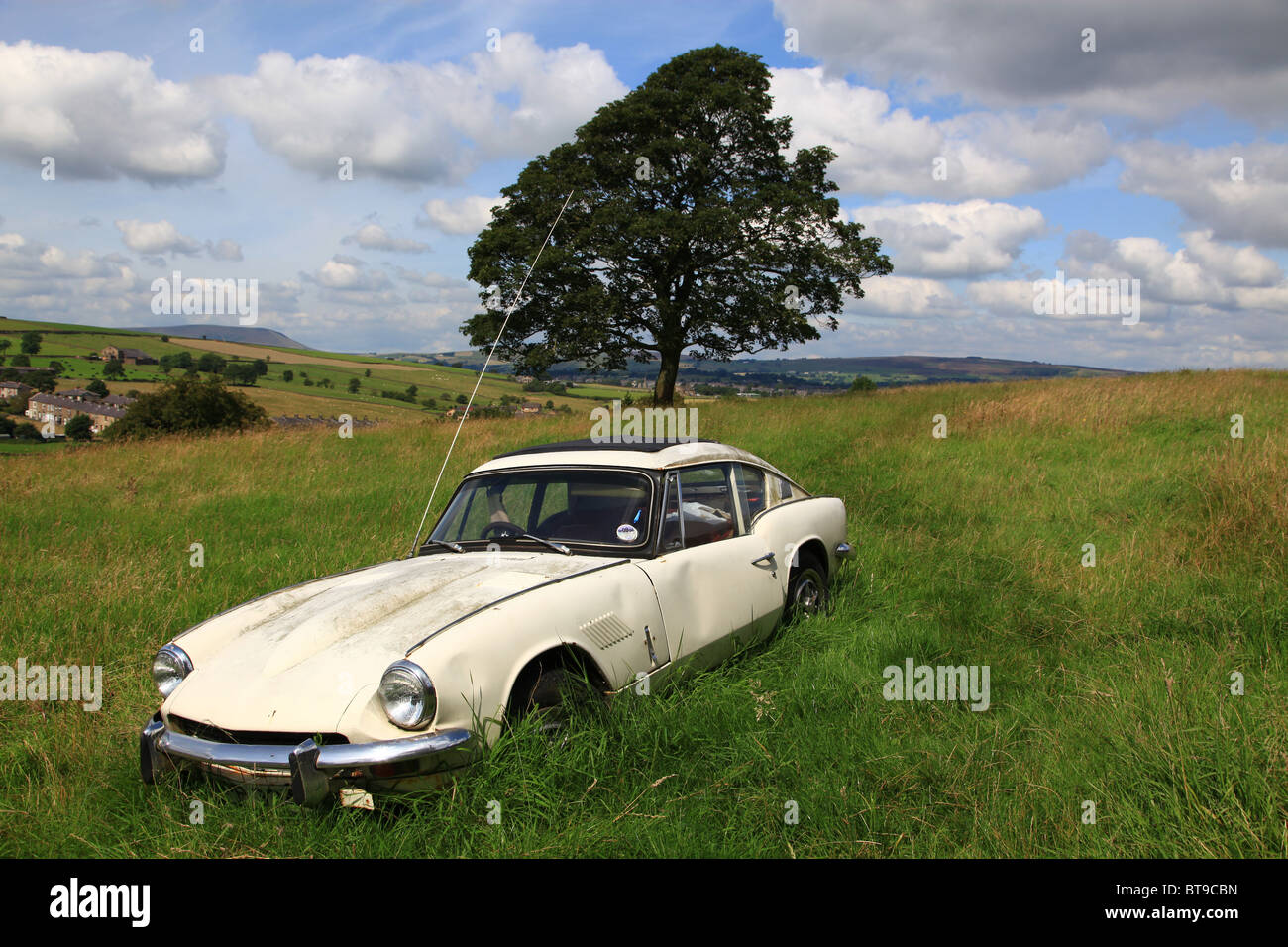 La formazione di ruggine e abbandonato Triumph GT6 mk11 in un campo a Trawen Colne Lancs Foto Stock